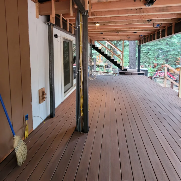 Covered deck with new joists and steel posts overhead and new decking laid
