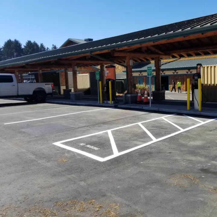 Vehicle charging station and new striping beside a timber carport