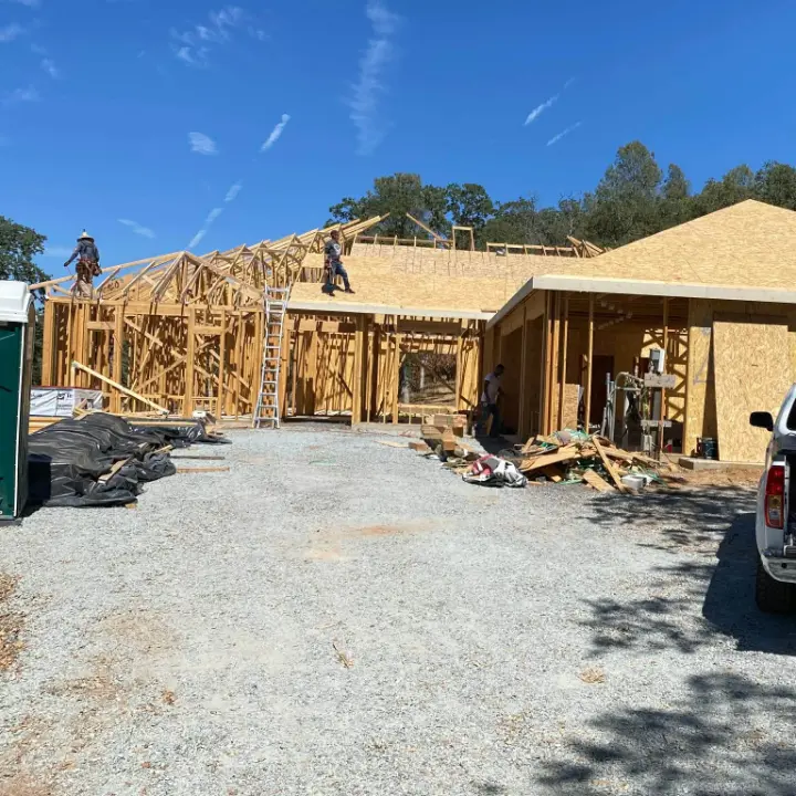 Crew setting roof trusses on a new home