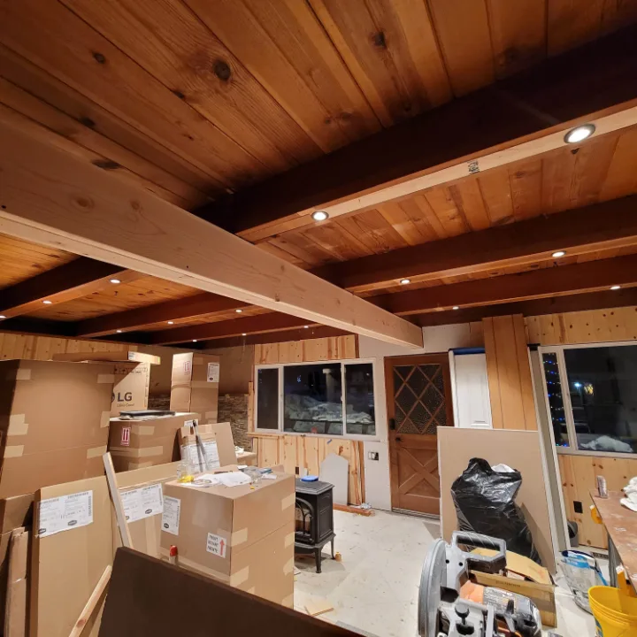 Interior renovation with new beams and recessed lighting in a wood ceiling