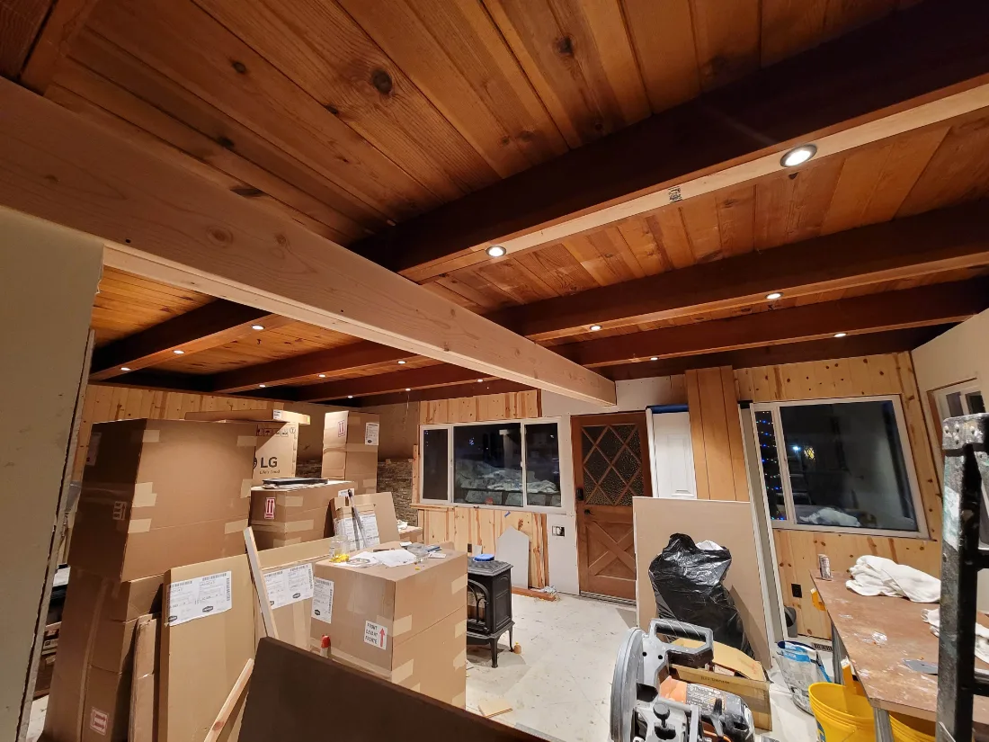 Renovation in progress: new beams and lighting in a wood ceiling, cabinets delivered and waiting