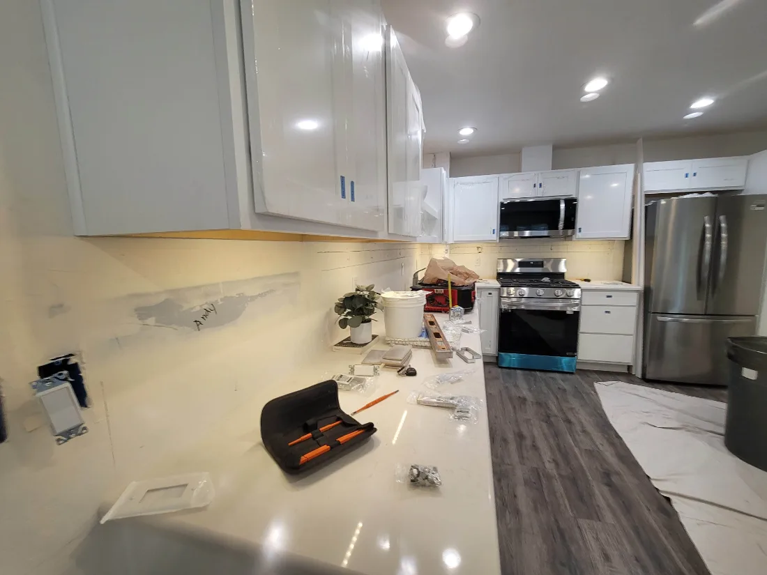 Kitchen remodel nearing completion: white cabinets, new counters and appliances