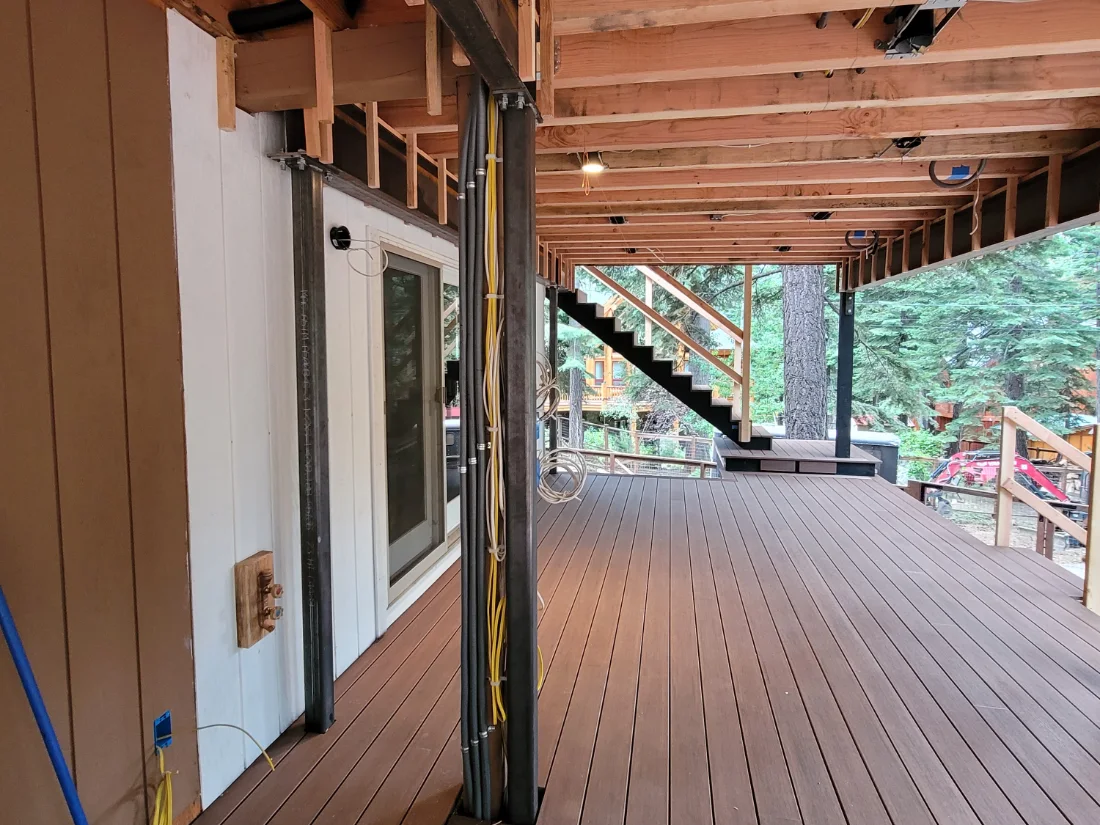 New joists, a steel beam and steel posts carrying an upper deck, with new decking below