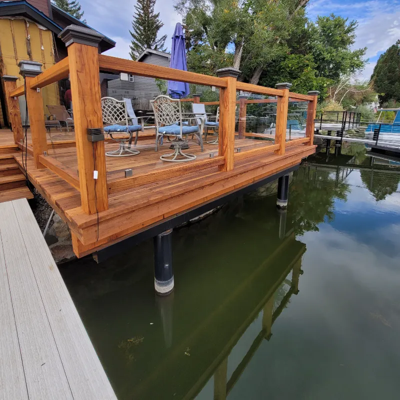 Finished wood deck with glass railing, built on piers