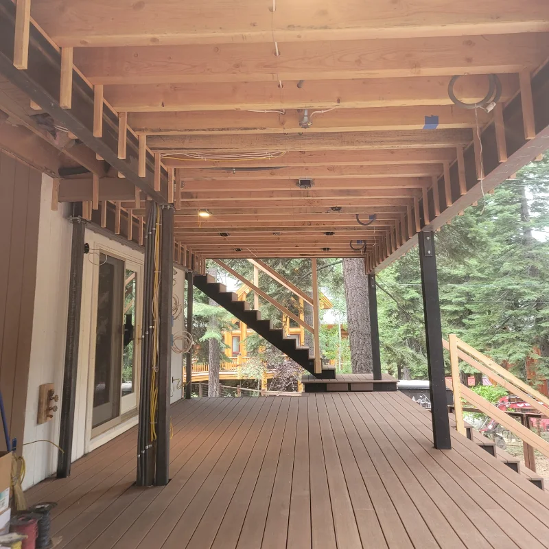 New joists and steel posts carrying an upper deck, seen from below